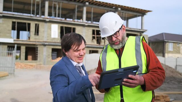 Contractor specialist and businessman planning new residential subdivision home building in construction site with digital tablet, argument developing. Worker man and investor meeting.