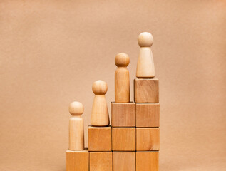 Leadership with business success and population growth concepts. Wooden figures, male and female standing on wood cube blocks growth graph step isolated on brown background, minimal and eco style.