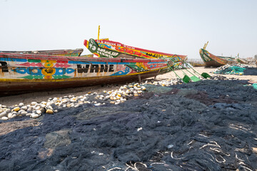 pirogues et leurs filets de pêche dans le quartier des pêcheurs traditionnels à Dakar au Sénégal en Afrique de l'Ouest - obrazy, fototapety, plakaty