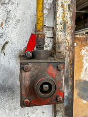A rusty red box with a red ball on top of it