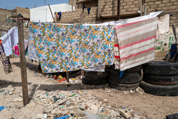 du linge sèche étendu sur un fil dans le port de pêche traditionnel de Dakar au Sénégal en Afrique - obrazy, fototapety, plakaty