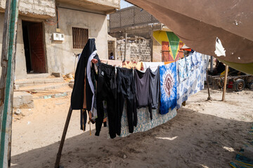 du linge sèche étendu sur un fil dans le port de pêche traditionnel de Dakar au Sénégal en Afrique - obrazy, fototapety, plakaty
