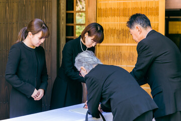お葬式で芳名録・芳名帳にサインする高齢者の日本人男女
