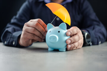 Man sheltering piggy bank with umbrella. Risk insurance in banking. Financial protection concept