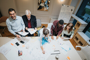 A dynamic team of multigenerational business colleagues engaged in a collaborative meeting,...