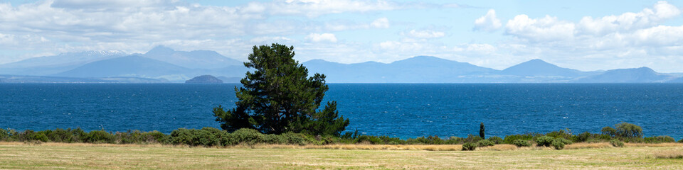 Panoramic view from Lake Taupo lookout: turquoise waters of the crater lake against the stunning backdrop of the Taranaki Mountains, North Island, New Zealand