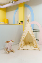 Wigwam tent for children's room with rocking toy. 