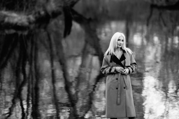 Naklejka premium Portrait of a young beautiful blonde girl outdoors. Black and white photo.