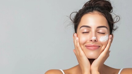 Portrait of beautiful latin woman touching her clean and healthy face against grey background. Smiling hispanic woman with natural makeup feeling healthy skin with eyes closed. Beauty care pampering. - obrazy, fototapety, plakaty
