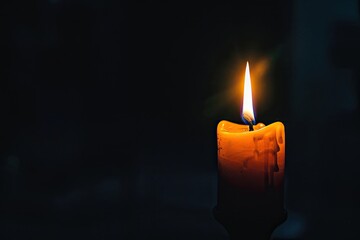 Single candle flame flickering in the vast darkness - obrazy, fototapety, plakaty