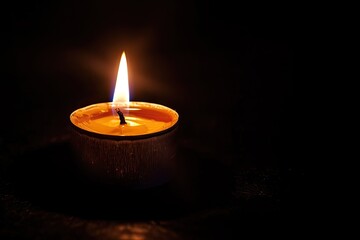 Single candle flame flickering in the vast darkness - obrazy, fototapety, plakaty