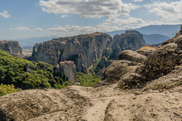 A historic monastery perched on towering cliffs amidst a serene rocky landscape in Meteora Greece