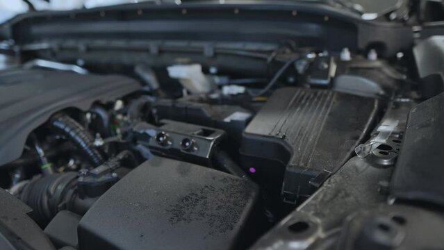 The engine compartment of a new car. Under the car hood: generator, engine, air filter, battery.