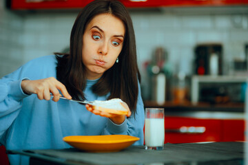 Woman Spreading Cheese Cream on Toast Bread for Breakfast. Girl making her breakfast with dietary...