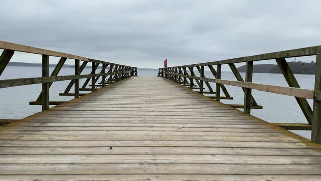 wooden bridge in the sea with cloudy weather