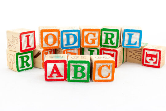 Multi-colored wooden letter blocks with ABC alphabets are selective focused isolated on white wood background