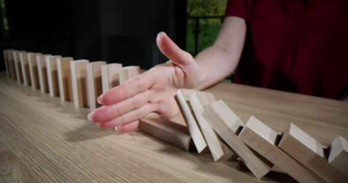 Domino effect stopping the chain reaction of wooden blocks