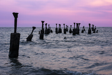 Old ruined sea piers in Calicut Kozhikode beach in Kerala India. Silhouettes of sea piers during the sunset