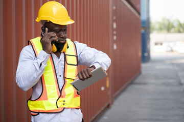 African logistic engineer man worker or foreman working with checking time at container site	