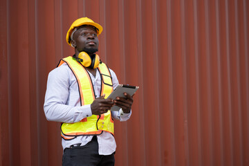 African logistic engineer man worker or foreman use tablet computer working at container site	