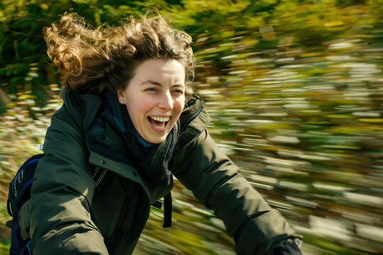 A woman laughing as she rides a bicycle through a sun-dappled forest, experiencing the sheer joy of movement.