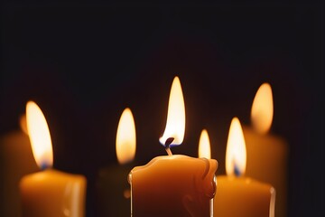 Candles ablaze casting a warm glow, wax slowly melting against a pitch black backdrop.