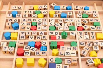 Wooden cubes with alphabets educational toy blocks in a box closeup..