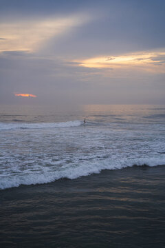 People surfing in sea during sunny day