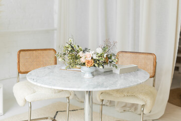 Stylish table with flowers and design book