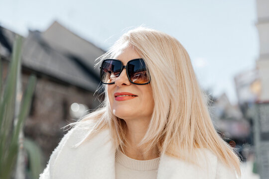 Mature woman with blonde hair wearing sunglasses on a sunny day