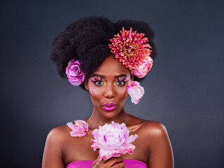 Beauty, flowers and hair with portrait of black woman in studio on dark background for natural...