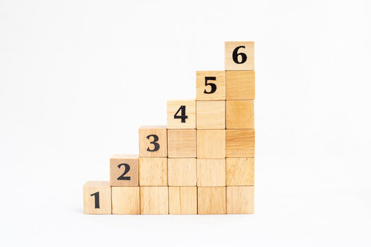 Wooden blocks stacking as step stair with numbers from 1 up to 6 isolated on white background. Business concept growth success process. Copy space.