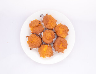 Homemade cupcakes in ceramic plate on white background. Top view.