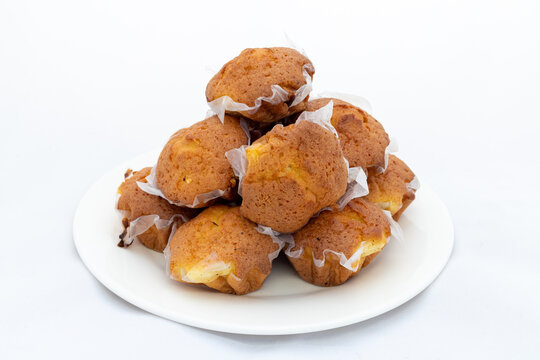 Homemade muffins cupcakes in plate on white background. Closeup view.