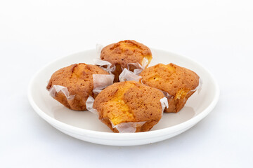 Fresh small cakes in ceramic plate on white background
