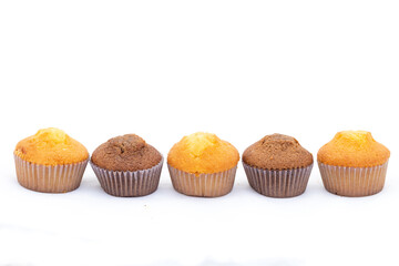 Different color cupcakes in a row on white background