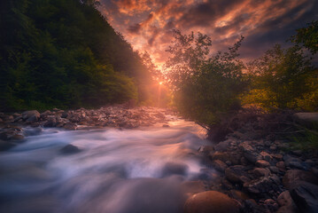 beautiful sunset over fast flowing mountain river