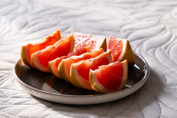 Sliced grapefruit on a plate. Red grapefruit slices in dish.