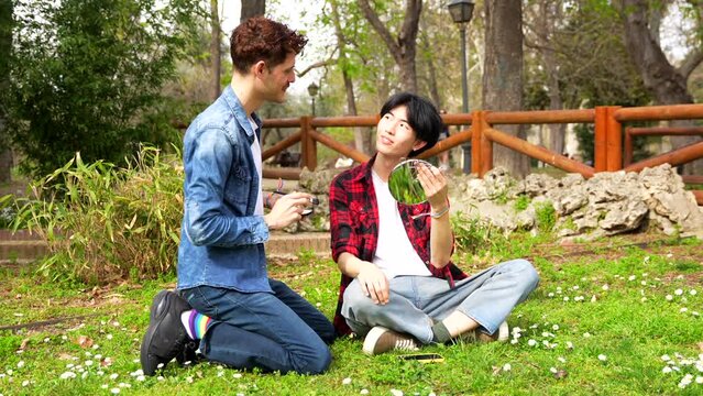 Gay man gesturing agreement making up in a park with his couple