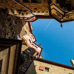 interior of a castle courtyard in Germany with a blue sky above and a plane crossing over the blue sky above