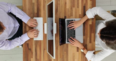 Two people work at computers in the office top view