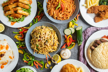 Table full of food photographed from above, beautifully garnished with flowers, featuring a variety...