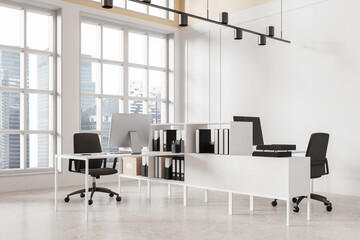 Obraz premium Stylish coworking room interior with pc computers on desk, panoramic window