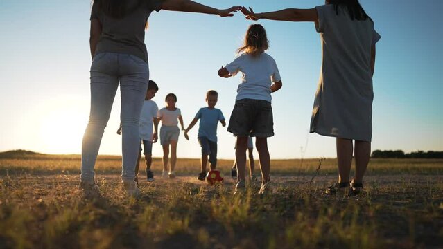 Football match in park at sunset.family in park with soccer ball, having fun.Fun for whole family playing in park at sunset.Family game in park fun with soccer ball on green grass.Happy family concept