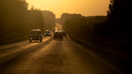Cars driving along the highway in the summer heat. Summer evening. Travel concept.
