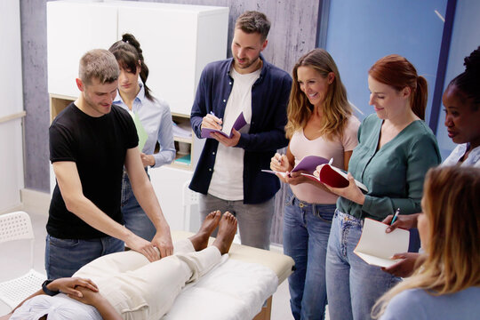 Male Instructor Teaching Massage Technique To Group