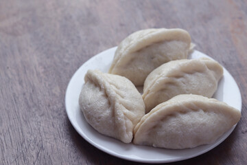 Delicious dumplings on a white plate on a wooden table