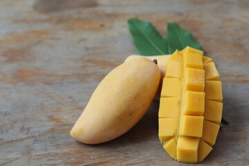 Fresh yellow mango fruit with mango sliced on wood background