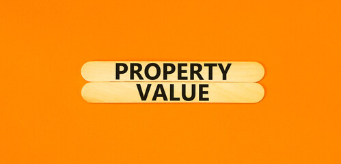 Property value symbol. Concept words Property value on beautiful wooden stick. Beautiful orange...