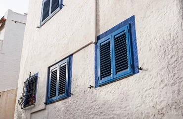 Foto auf Leinwand Geschlossene blaue Fensterläden an einem Haus in Sitges, Spanien © Robert Poorten